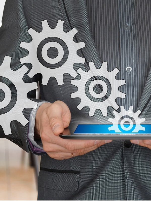 businessman holding tablet with cogs